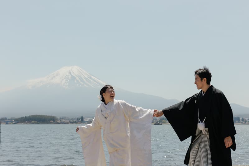 河口湖のほとり、富士山を背に白無垢の袖を広げる